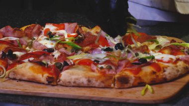 İtalyan pizzası hazırlayan şefin yakın çekim. Çerçeve. Profesyonel şef, geleneksel İtalyan pizzası ile yeşillikleri dekore eder. Ağzınızı sulama olacak Lezzetli İtalyan pizza,