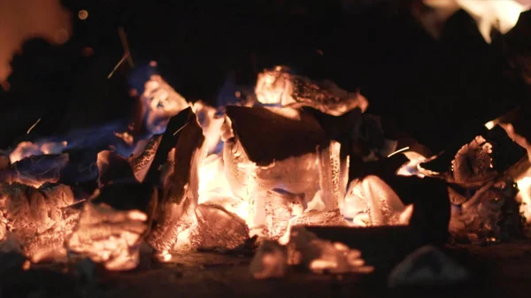 Nahaufnahme brennender schwarzer Kohlen. Aktion. Beim Grillen in der Natur lodern kleine Flammen auf Kohlen. heiße und warme glühende Kohlen zum Zünden — Stockfoto