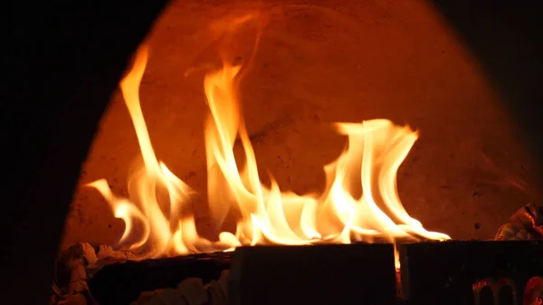 Nahaufnahme einer Feuerflamme, die im Ofen brennt. Rahmen. schön lodernde Flamme des Feuers in traditionellen Holzofen. Feuer im Herd zum Kochen — Stockfoto