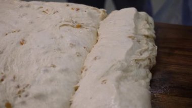 Kuru üzüm ile maya hamur yakın çekim. Stok görüntüleri. Pişirme için hazır tatlı kuru üzüm ile Çiğ hamur. Tatil veya etkinlik için tatlı hamur işleri yapma