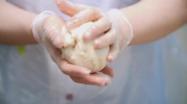 Paskalya kekleri için hamur yoğurma aşçı yakın çekim. Stok görüntüleri. Cook kuru üzüm ile maya hamur parçası buruşturarak ve paskalya kek için kalıp koyar