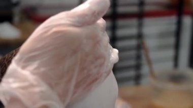 Şefin yakın çekim paskalya pastası sırlar. Stok görüntüleri. Eldiven Baker paskalya kutlaması için beyaz krem kek sırlar