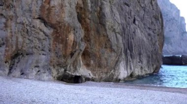 Mavi deniz ile kıyı kayalıkların görünümü. Madde. Mavi deniz ve kayalıklar ile mükemmel bir yaz alanı. Su üzerinde yükselen kayalıklar ile Seascape. Çakıl taşları ve kayalık kayalıklarla dolu plaj ruhu büyülüyor