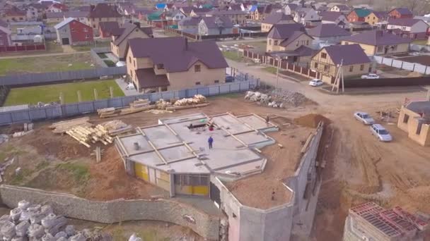 집의 콘크리트 베이스의 최고보기. 클립. 건설 현장 근로자는 시골 별장의 배경으로 건설 중인 주택의 콘크리트 베이스를 확인합니다. — 비디오