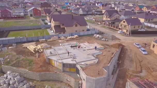 Evin beton tabanıüst görünümü. Klip. Şantiyede çalışanlar, kırsal evlerin arka planında inşaat aşamasındaki evin beton temelini kontrol ediyor — Stok video