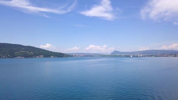 青空を背景に町の山の海岸と美しい海の風景のトップビュー。アクション。夏休みのための山岸の楽園に位置する美しい町と青い海 — ストック動画