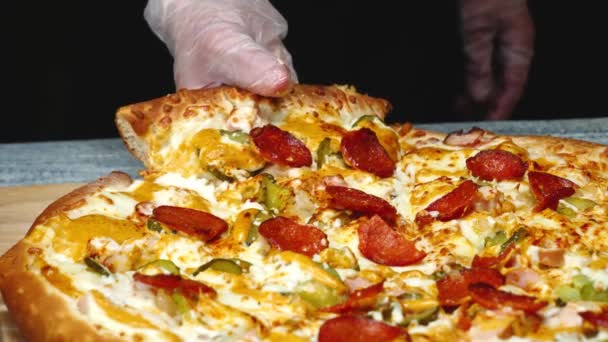 Närbild av man tar läcker bit pizza med ost. Ram. Man tar bit av italiensk pizza och drar aptitretande smält ost — Stockvideo