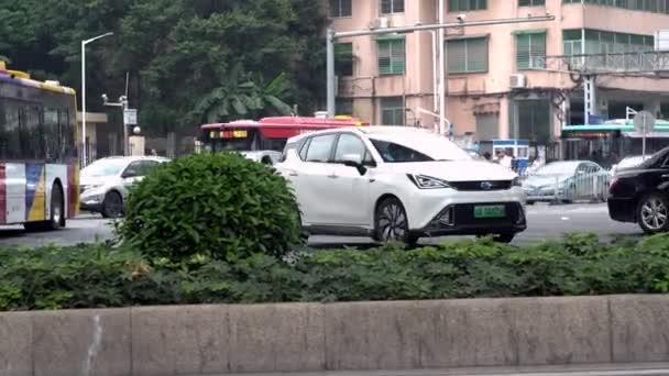 Guangzhou, Chine - Mai 2019 : Vue de la chaussée avec des voitures et des bus dans la ville. Les médias. Tourner route de ville avec flux de transport en Chine. Buissons verts le long de la route de la ville en Chine — Video