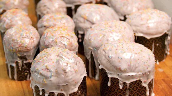 Chiudere per le tradizionali torte pasquali in carta artigianale in piedi su tavola di legno, cibo e concetto di cottura. Filmati delle scorte. Torte di Pasqua fatte in casa con smalto bianco sul tavolo marrone . — Foto Stock