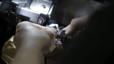 Yakın adam elleri birlikte kırık telleri bantlayarak arabada elektrik tamir. Eylem. Erkek işçi siyah bant ile sarma telleri eller.
