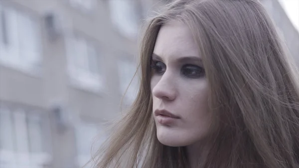 Buitenschoonheid portret van jong bruin haired meisje kijkt opzij over wazig stad lijn achtergrond. Actie. Close-up voor vrouw gezicht met heldere rokerige ogen, make-up concept. — Stockfoto