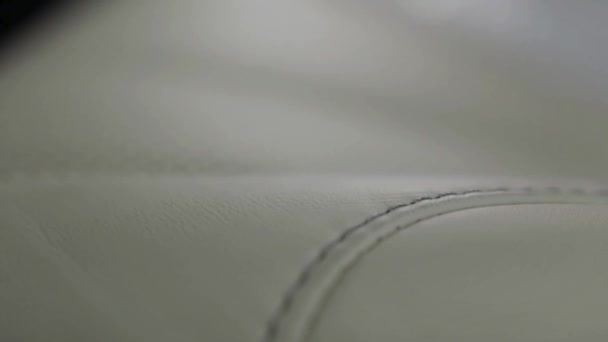 Gros plan pour cuir blanc texturé cousu de luxe intérieur de voiture. L'action. Fond en cuir cousu propre, blanc et beige à l'intérieur de la nouvelle voiture de luxe . — Video