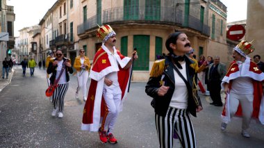 İspanya, Barselona 'da kostüm geçidi. - Sanat. Parlak, alışılmadık giysiler içindeki birçok insan şehrin dar sokaklarında yürüyor, dans ediyor ve kutluyor..