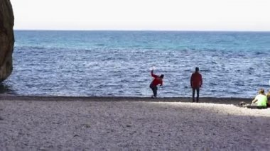 Bir grup arkadaş deniz kıyısında dinleniyor, suya stoklar atıyor ve Pasifik Okyanusu, California 'da piknik yapıyorlar. - Sanat. İnsanlar denizin önünde eğleniyor..