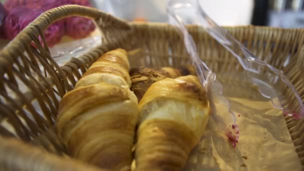 Wicker basket with French pastry standing on glass display in the bakery, food concept. Art. Homemade pastry, close up for freshly baked French croissants. — Stock Video