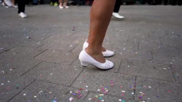 Cierre para las piernas de hombres y mujeres en zapatos blancos bailando en la calle durante la fiesta nacional. Art. Costumbres y tradiciones españolas, celebración del carnaval con gente de esgrima . — Vídeo de stock