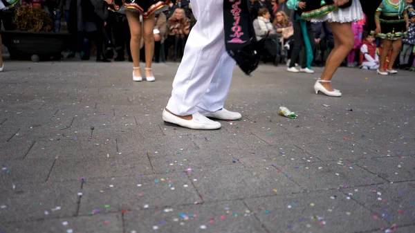 Zblízka pro nohy mužů a žen v bílých obuvi tančí na ulici během státního svátku. Umění. Španělské zvyky a tradice, karnevalová oslava s tančícími lidmi. — Stock fotografie