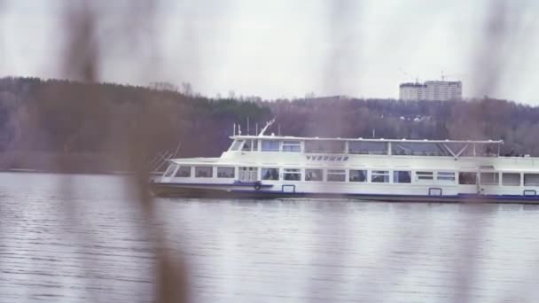 Rivier passagiers veerboten. Stock footage. Uitzicht vanaf de kust op het passeren van twee verdiepingen eenvoudig passagiersschip. Vervoer van passagiers per veerboot over Gray River in bewolkt weer — Stockvideo