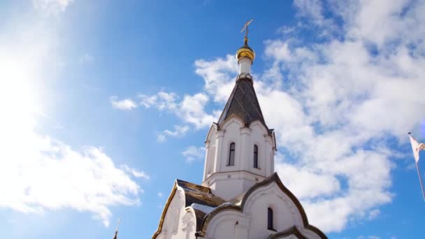 Mavi gökyüzü arka planda Ortodoks beyaz kilise. Stok görüntüleri. Dini Tema Ortodoksluk ve Hıristiyanlık ile ilişkili. Güzel gökyüzüne karşı küçük bir altın kubbe ile kilisenin bir parçası — Stok video