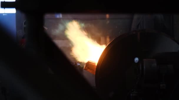 作業員は、工場で火災で炉内の金属を溶かします。ストック映像。グリーン言語で炎を上げ、炉内の金属を溶かす形で、ヘルメットの労働者 — ストック動画