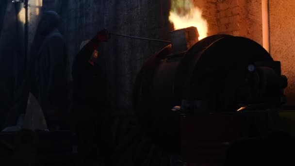 Trabajadores de la planta metalúrgica que trabajan con metal caliente. Imágenes de archivo. Los trabajadores en uniformes y cascos trabajan con metales calientes peligrosos a altas temperaturas en la antigua fábrica metalúrgica — Vídeo de stock