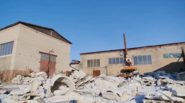 Terkedilmiş fabrikada çok fazla çöp var. Stok görüntüleri. Mavi gökyüzü arka planda terk edilmiş bitkinin arkasında beyaz çöp yığını. Fabrika içinde çöp kurtulmak için çevre dostu bir yöntem değil