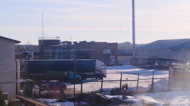 Widok na teren zakładu przemysłowego na tle błękitnego nieba. Materiały stockowe. Ogromny samochód ciężarowy stoi na parkingu w zakładzie przemysłowym przed błękitnym niebem z jasnym słońcem — Wideo stockowe