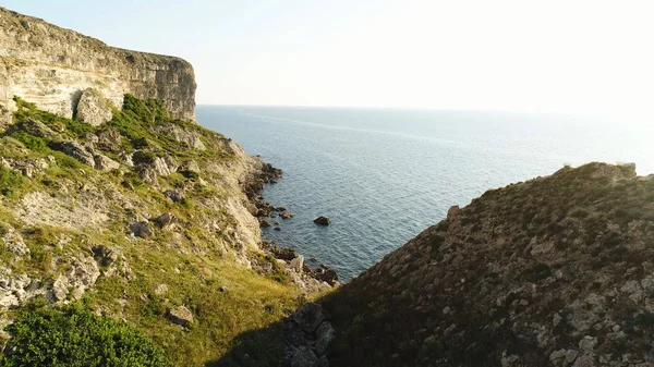 Spektakulär utsikt över branta dliffs vid havet, Irland. Skott. Grön sluttning nära lugnt vatten och den ändlösa horisonten på klarblå himmel bakgrund. — Stockfoto