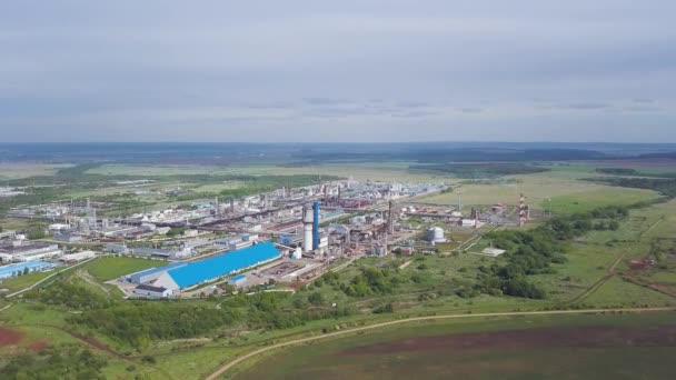 Breathtaking aerial view of the industrial area with factory surrounded by green meadows and trees. Clip. Agricultural area fields with juicy grass and trees near recycling plant. — ストック動画