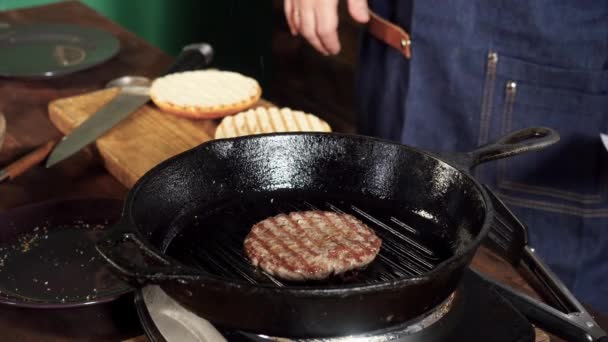 Dökme demir ızgarada kızaran hamburger köftesi. Stok görüntüleri. Hamburger Patty ızgara tavada hazırlanır — Stok video