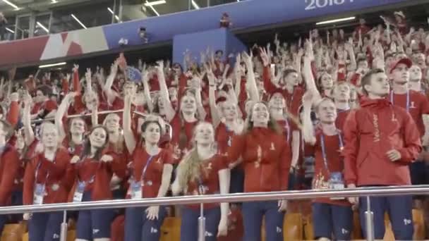 俄罗斯，莫斯科 - 2018年7月15日：许多球迷在体育场举手，体育概念。行动。身着红色T恤的球迷在比赛期间支持球队. — 图库视频影像