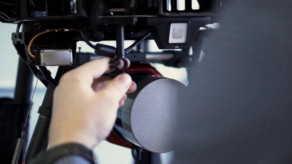 Back view of a man installing camera in quadrocopter, preparation for the flight. Clip. Close up for the process of drone setup and drone assembly, modern technologies concept.