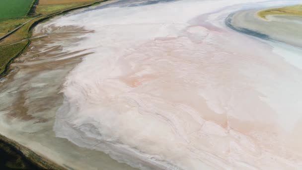 Verbazingwekkende schoonheid van gedroogde zoute meer van licht beige kleur omgeven door groene en gele velden. Neergeschoten. Luchtfoto van helder zoutwaterreservoir in de vroege herfst. — Stockvideo