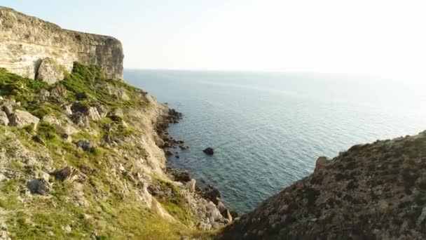 Spektakulär utsikt över branta dliffs vid havet, Irland. Skott. Grön sluttning nära lugnt vatten och den ändlösa horisonten på klarblå himmel bakgrund. — Stockvideo