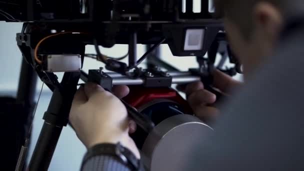 Achteraanzicht van een man die camera 's installeert in quadrocopter, voorbereiding op de vlucht. Een knip. Close-up voor het proces van drone setup en drone montage, moderne technologieën concept. — Stockvideo