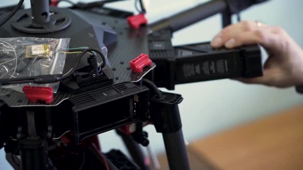 Sluiten voor handen zetten batterij in de quadcopter, filmen voorbereiding. Een knip. Drone setup, het invoegen van accumulator in de machine. — Stockvideo