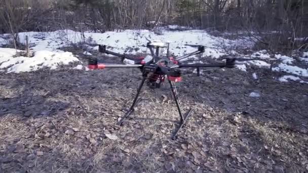 Close up per quadricottero in piedi a terra nella foresta prima del volo, concetto di tecnologie moderne. Clip. Drone con fotocamera digitale su erba è pronto a scattare foto e registrare filmati . — Video Stock