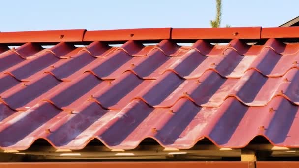 Techo rojo y cielo azul. Imágenes de archivo. Techo de pizarra roja de la casa — Vídeo de stock