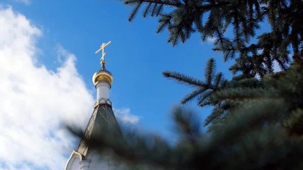 Bílý kostel proti modré obloze se zlatými dómy. Skladní záběry. Pohled na zlatou kopuli chrámu proti modrému nebi — Stock fotografie