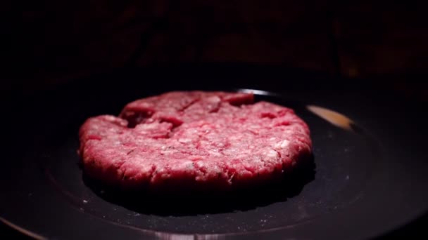 Niet gekookt vlees kotelet valt in de pan. Stock footage. Hamburger Patty valt op de pan om te koken — Stockvideo