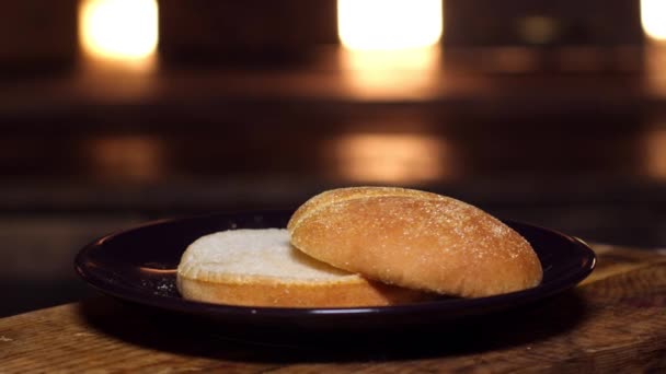 Du pain burger dans une assiette. Images d'archives. Petit pain appétissant pour cuisiner un hamburger. Délicieux aliments — Video