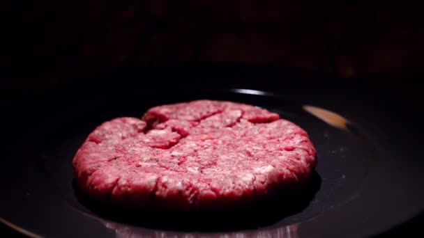 Niet gekookt vlees kotelet valt in de pan. Stock footage. Hamburger Patty valt op de pan om te koken — Stockvideo