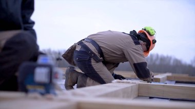 İşçi ahşap tahta ölçümleri notlar alır. Klip. Kask şeklinde işçi inşaat testere için ahşap tahta üzerinde ölçümler imar kayıtları