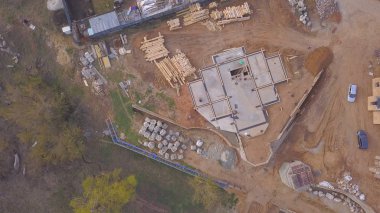 Evin beton tabanıüst görünümü. Klip. Şantiyede çalışanlar, kırsal evlerin arka planında inşaat aşamasındaki evin beton temelini kontrol ediyor