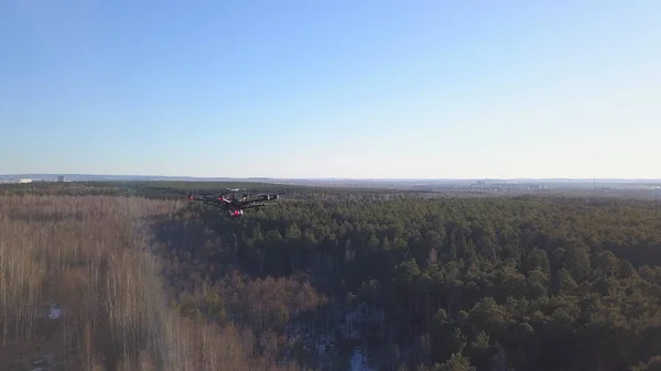 Quadcopter falls to ground. Clip. Top view of quadcopter lost communication and begin to fall to ground. Quadcopter in air on background of forest with horizon of blue sky