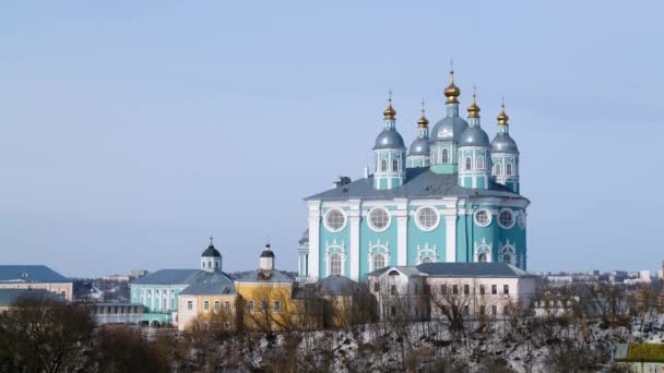 冬の街を背景に美しい青い寺院。ストック映像。スモレンスクの仮定大聖堂は、背景の空に都市の上に上昇します — ストック動画