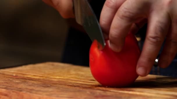 木製の板に赤いトマトを切る。ストック映像。シェフが木製のボードにトマトを切った — ストック動画