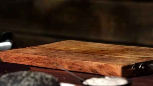 Ξύλινη σανίδα κοπής στην κουζίνα. Υλικό από μετοχές. Παλιά άδεια ξύλινη περικομμένη σανίδα κοπής στο φόντο κουζίνα. Κοντινό — Αρχείο Βίντεο