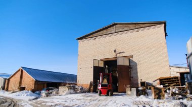 Üretim yerinde Asansör ile kamyon. Stok görüntüleri. Küçük Forklift kamyon kışın büyük ambar arka planda bitki üretim alanında sürüş