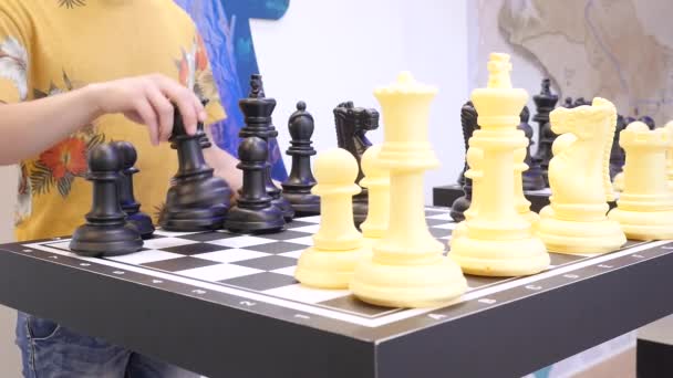 Młody człowiek gra wielkie szachy drukowane na drukarce 3D. Media. Wysoki rozwój techniczny na przykładzie życia — Wideo stockowe